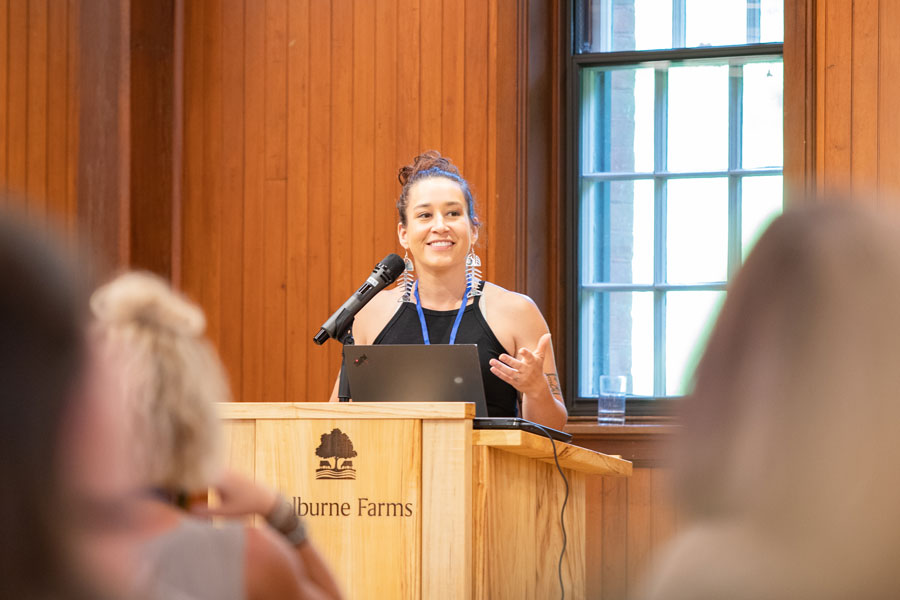 A person is speaking at a podium with a microphone and laptop.