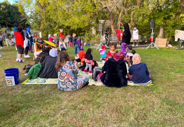 families sit on picnic blankets at an outdoor fall event